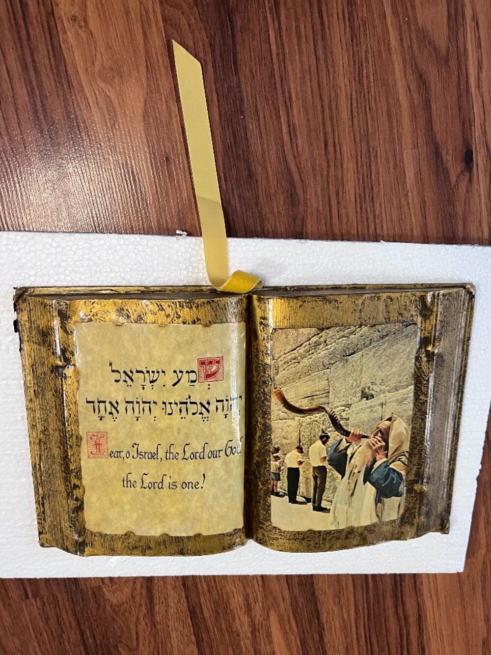 A decorative open-book tabletop item featuring a gold finish.